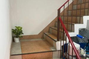 a staircase with a red railing and a plant at Sleep Break Hostel Sathon in Bangkok