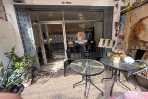 a couple of tables and chairs in front of a store at Sleep Break Hostel Sathon in Bangkok