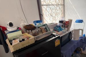 a counter with a dishwasher with food and other items on it at Sleep Break Hostel Sathon in Bangkok