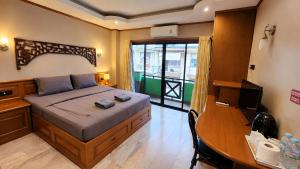 a bedroom with a bed and a desk with a computer at Max Residence in Pattaya