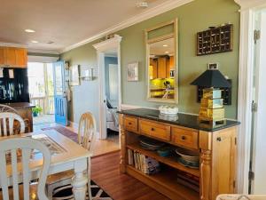 a dining room with a table and a mirror at Clamelot in Holden Beach