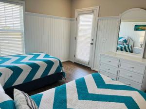 a bedroom with two beds and a mirror at Avalon East-Duplex in Holden Beach