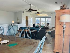 a living room and dining room with a dining table at Beach Ya There in Holden Beach