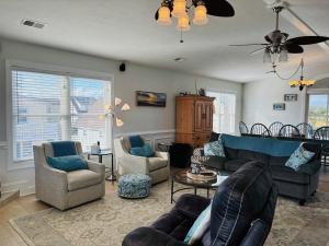 a living room with couches and chairs at Beach Ya There in Holden Beach