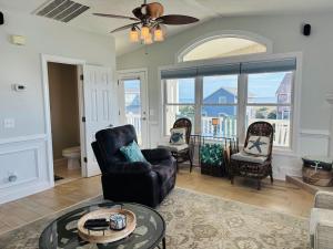 a living room with chairs and a table at Beach Ya There in Holden Beach +63 photos
