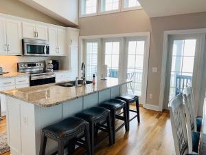 a kitchen with a island with bar stools at The Seventh Day in Holden Beach
