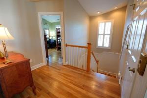 a hallway of a home with wooden floors and a door at The Seventh Day in Holden Beach