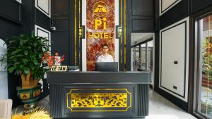 a man standing behind a fireplace with a laptop at Pi Hotel Phố cổ Hoa Lư in Kỳ Vĩ