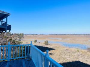 a blue porch with a view of a field at Victoria in Holden Beach