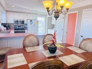 a kitchen with a wooden table with chairs and a dining room at Victoria in Holden Beach