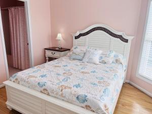 a bedroom with a bed with a white bed frame at Victoria in Holden Beach