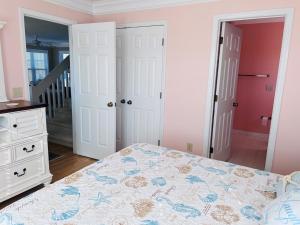 a bedroom with a bed and a dresser at Victoria in Holden Beach +46 photos