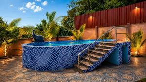 a pool with a staircase and a statue of a bird at Happy Mates Forest Villa in Pondicherry +8 photos