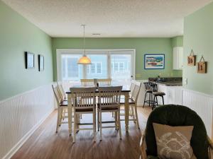 a dining room and kitchen with a table and chairs at Tradewinds in Holden Beach