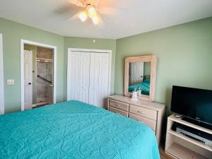 a bedroom with a bed and a mirror and a television at Tradewinds in Holden Beach