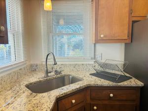 a kitchen counter with a sink and a window at Plan Beach home in Holden Beach