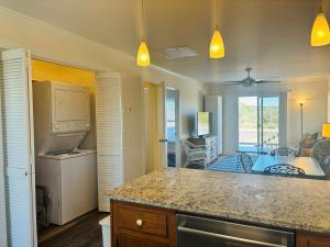 a kitchen with a counter top and a living room at Plan Beach home in Holden Beach