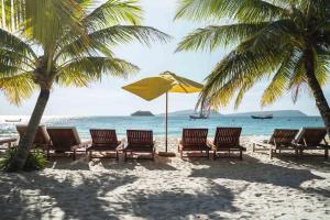 a group of chairs and an umbrella on a beach at Home Escape Resort in Phumĭ Bát Tráng (2)