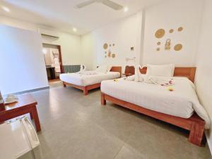 a hotel room with two beds and a table at Home Escape Resort in Phumĭ Bát Tráng (2)