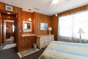 a bedroom with a bed and a sink and a mirror at Yellow Bird in Holden Beach