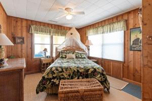 a bedroom with a bed and a ceiling fan at Yellow Bird in Holden Beach