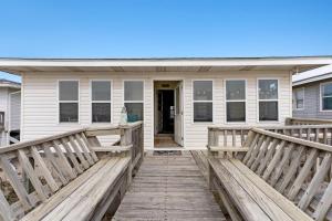 a house with a wooden ramp leading to the front door at Yellow Bird in Holden Beach