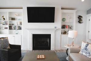 a living room with a fireplace with a flat screen tv at Nautilus Home in Holden Beach