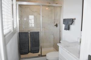 a bathroom with a shower and a toilet at Nautilus Home in Holden Beach +46 photos