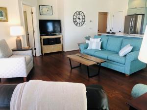 a living room with a blue couch and a table at Holden Hideaway condo in Supply