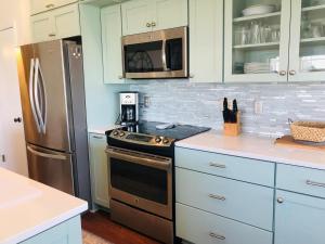 a kitchen with a stove and a stainless steel refrigerator at Holden Hideaway condo in Supply