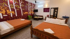 a bedroom with two beds and a living room at Happy Mates Forest Villa in Pondicherry