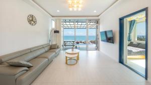 a living room with a couch and a view of the ocean at yeongdeok chaeumneul poolvilla in Yŏngdŏk