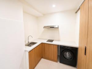 a small kitchen with a washer and dryer in it at Asteria Ocean Residence in Danang