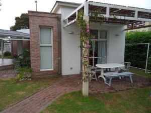 a white house with a table and a bench at Quinta Un Sueño Junin in Junín