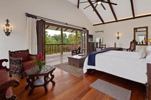 a bedroom with a large bed and a balcony at El Lugar Hotel & Nature Reserve Costa Rica in Tigre