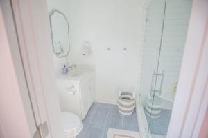 a bathroom with a toilet and a sink and a shower at Three Girls in Holden Beach +51 photos