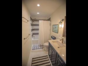a bathroom with a shower toilet and a sink at Three Girls in Holden Beach