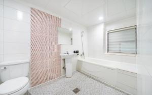 a white bathroom with a toilet and a sink at Romance Hotel in Seoul +129 photos