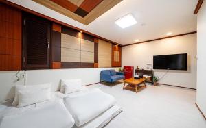 a living room with a white couch and a flat screen tv at Romance Hotel in Seoul