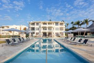 a pool with chairs and umbrellas in front of a hotel at Paradisus by Meliá Palma Real Golf and Spa Resort - All Inclusive in Punta Cana