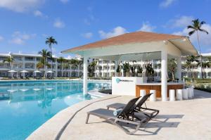 a lounge chair next to a pool at a resort at Paradisus by Meliá Palma Real Golf and Spa Resort - All Inclusive in Punta Cana