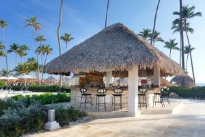 a bar with chairs and a straw roof at Paradisus by Meliá Palma Real Golf and Spa Resort - All Inclusive in Punta Cana