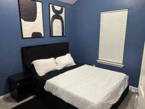 a blue bedroom with a white bed and a blue wall at Elegant luxurious paradise in Decatur