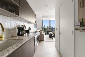a kitchen with white counters and a view of a living room at Luxury Penthouse Best Price ,Breathtaking Balcony Views, Ocean & City, Resort Pool, Spa, Gym, in Miami