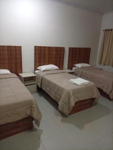 a hotel room with two beds in a room at Hotel Central Cardinal Pedro Juan Caballero in Pedro Juan Caballero