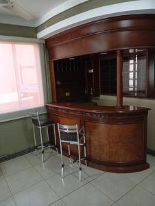 a bar in a room with two chairs at Hotel Central Cardinal Pedro Juan Caballero in Pedro Juan Caballero
