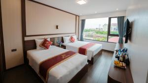 a hotel room with two beds and a window at Pi Hotel Phố cổ Hoa Lư in Kỳ Vĩ +65 photos