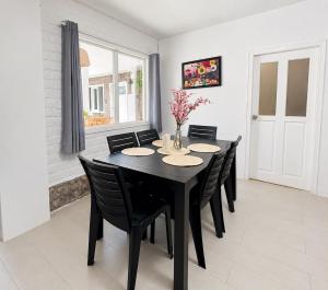 a dining room with a black table and chairs at Riverside Estate with Jacuzzi 9 Bedroom 7 Bath in Baños +4 photos