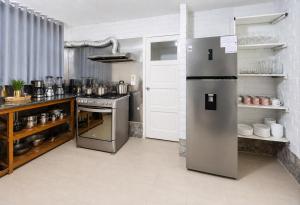 a kitchen with a stainless steel refrigerator and a stove at Riverside Estate with Jacuzzi 9 Bedroom 7 Bath in Baños