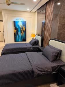 two beds in a bedroom with a painting on the wall at Emanzara in Islamabad +27 photos